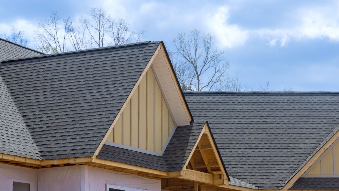 Overlapping asphalt shingles on the roof of a newly built home.