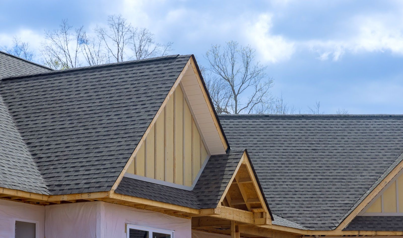Overlapping asphalt shingles on the roof of a newly built home.