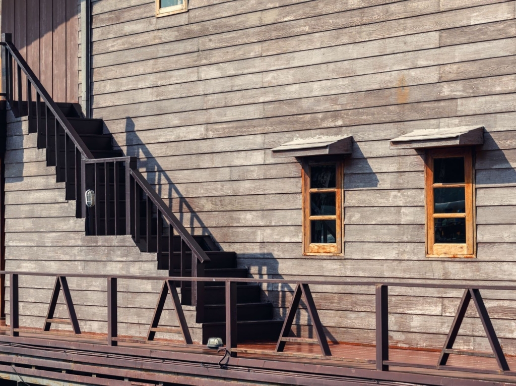Hardwood building exterior with stairs and window installed by a siding company.