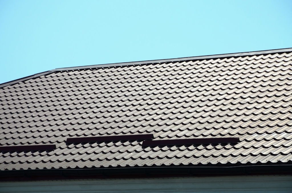 A close-up of a dark-colored metal tile roof.