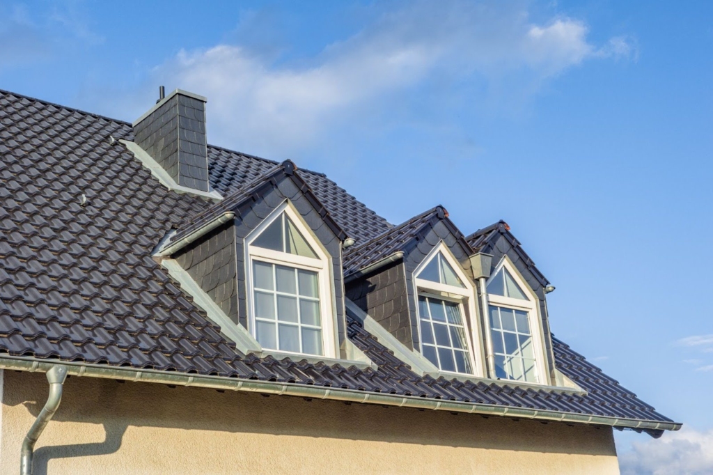 Home with a shingle roof and a clear sky in the background.