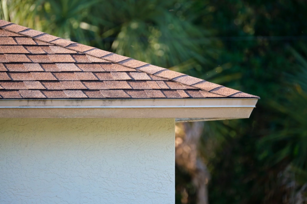 Close-up of one side of a house roof with asphalt shingles.