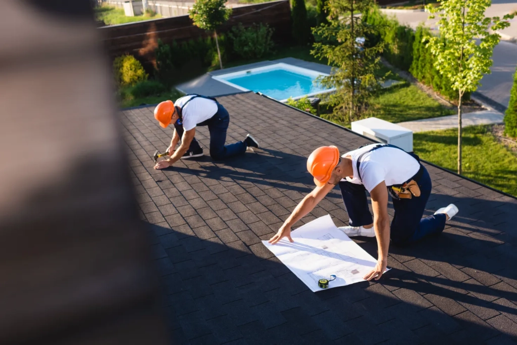 Two professionals put the finishing touches on a commercial roof replacement.